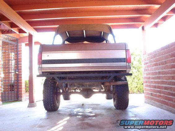 Brown 1987 Ford Bronco rear view, lifted with aftermarket bumper and soft top