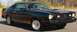 1977 Ford Mustang II - This 1977 Ford Mustang II coupe features a distinctive gold stripe along its side and a prominent hood scoop.