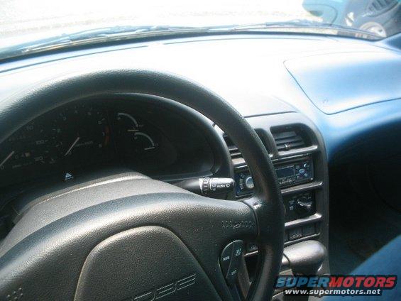 Car interior showing steering wheel, dashboard, and radio. Text on steering wheel says 'PROBE'