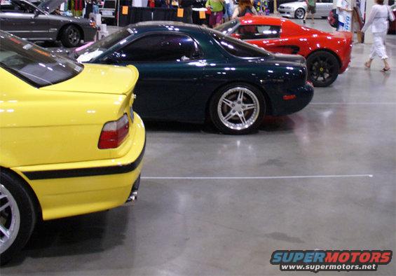 Yellow car rear quarter panel with black trim and spoiler