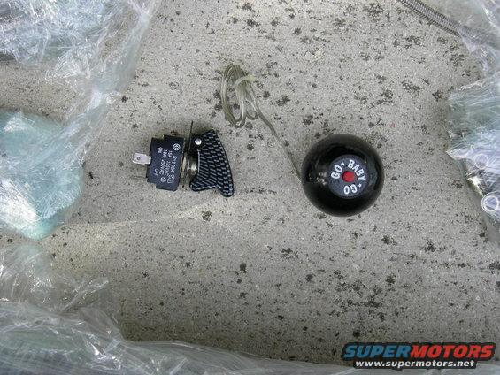 Black shift knob with 'GO BABY 09' text and a toggle switch