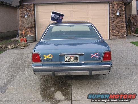 Blue sedan with a Bush-Cheney '04 flag on the roof, parked in a driveway