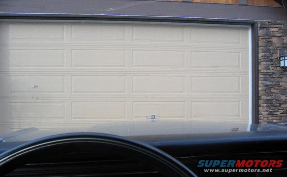 Car dashboard and steering wheel in front of a closed garage door