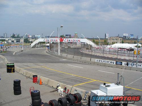 Race track with Canadian bridge overhead and stacks of tires on the side