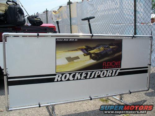 Banner with a race car ad, says 'Come Ride With Us' and 'FLEXOVIT ABRASIVES ROCKETSPORTS'