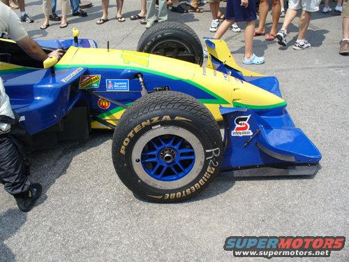 Blue and yellow open-wheel race car with Bridgestone tires and various sponsor decals