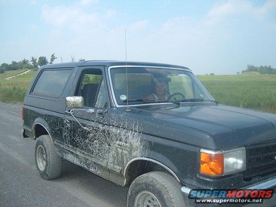 Mud-splattered dark SUV, 3q-front view. Appears to be a 1987 model