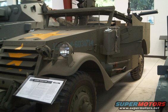 Olive drab military half-track with yellow stars and serial number 12031714, armed with a machine gun