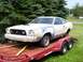 1978 Ford Mustang II - A white Ford Mustang II is being transported on a trailer, with primer visible on the front fender.