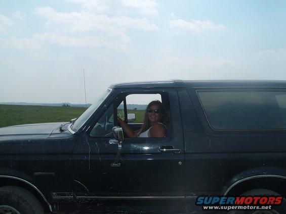 Side view of a dark 1988 Ford Bronco with a woman driving