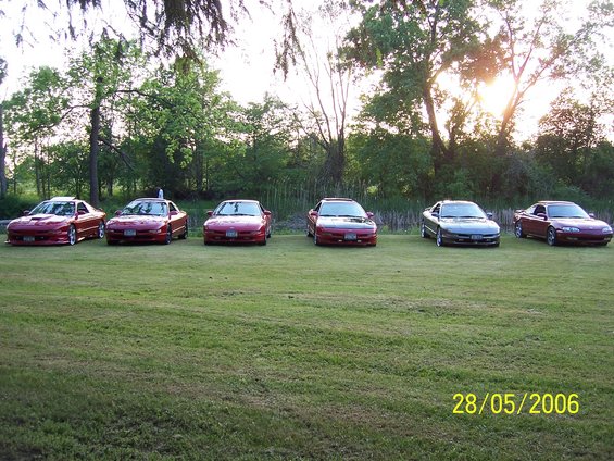 Six coupes parked in a field, one gray and five red. Date stamp reads 28/05/2006