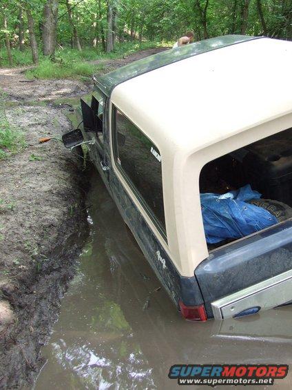 1986 Ford Bronco stuck in a muddy ditch off-road
