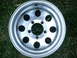 2001 Dodge 2500 - A single aluminum wheel with a five-lug bolt pattern is shown against a grassy background.