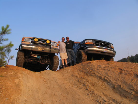 1993 Ford Bronco and another Ford truck on a dirt hill with two men