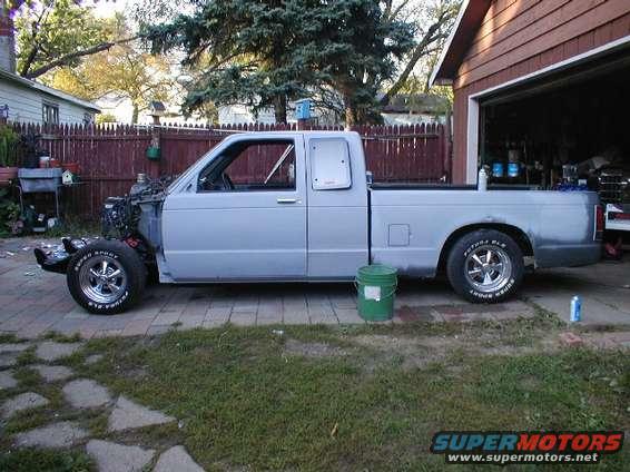 Light blue pickup truck, side view, missing front end, parked in driveway