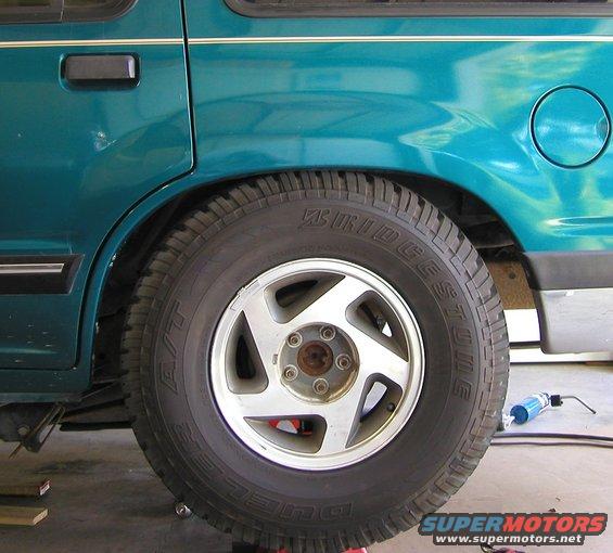Teal SUV rear wheel and fender with Bridgestone tire