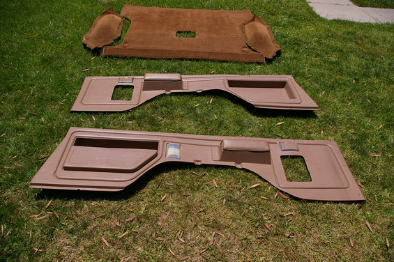 Brown interior trim panels and carpet laid out on grass