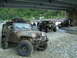 1989 Jeep YJ - Several Jeeps, including a 1989 YJ, are parked near a river under a bridge.