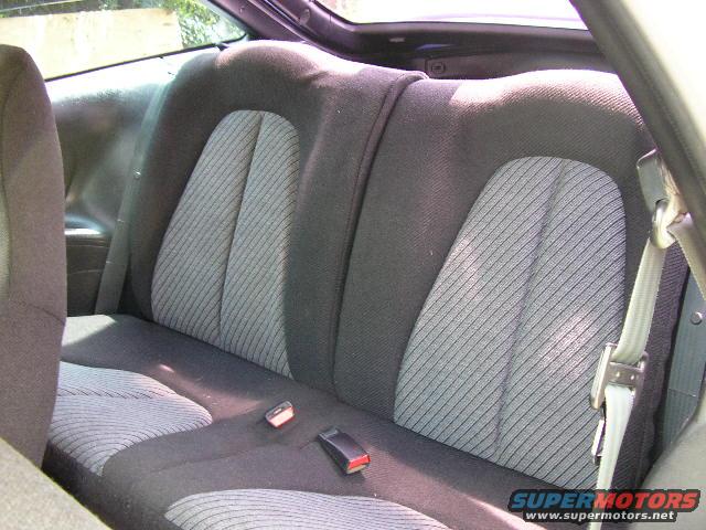 Back seat of a car with patterned fabric and seatbelts