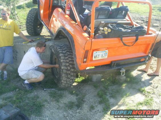 Orange off-road vehicle with large tires, a roll cage, and a license plate reading WKY 639