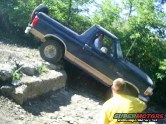 1994 Ford Bronco navigating a steep, rocky incline with a driver inside