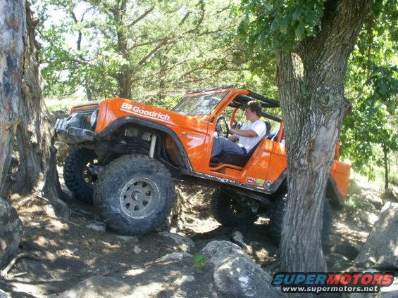 Orange 1994 Ford Bronco off-roading over rocks
