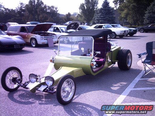 Lime green custom hot rod with black top, purple interior, and exposed front wheels