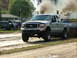 2000 Ford F-250 - Silver Ford F-250 truck with dual exhaust stacks blowing black smoke during a pull competition.