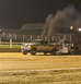 2000 Ford F-250 - A silver 2000 Ford F-250 truck is seen in a pull competition, emitting a large cloud of black smoke from its exhaust pipes while towing a t…
