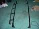 1991 Ford Bronco - Two parts of a ladder rack system are shown on a carpeted floor.