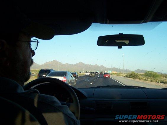 Interior view of a car on highway with traffic and mountains