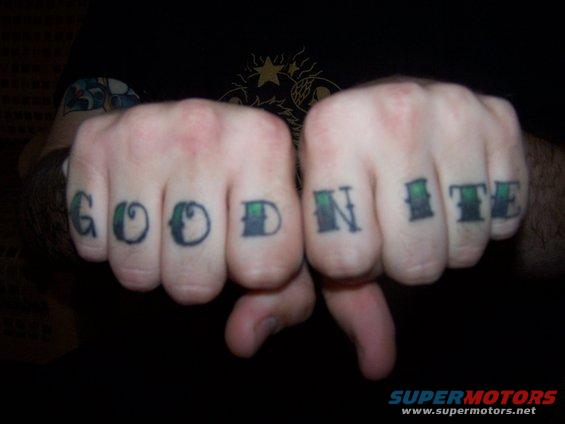Knuckles tattooed with "GOOD NITE" in black and green ink