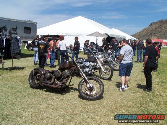 Chopper motorcycle with rusty brown tank and exposed engine, parked on grass