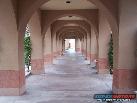 Arched walkway with columns and circular markings on the ground