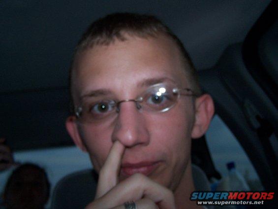 Man picking nose inside car interior
