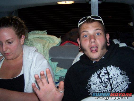 Interior view of a vehicle with two people, one with sunglasses on head