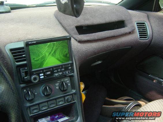 Car interior showing dashboard with aftermarket screen displaying green fractal pattern