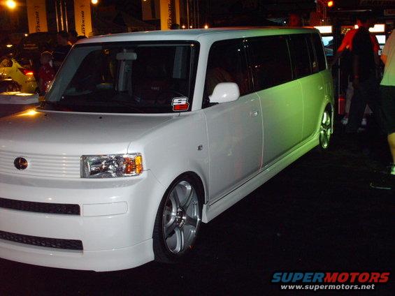 White Scion xB with custom wheels and body kit parked indoors