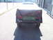 1991 Ford Bronco - Rear view of a trailer with a tarp covering its contents, parked outdoors.