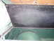 1991 Ford Bronco - Interior view of a vehicle's storage compartment with the lid open, revealing green lining and wiring.