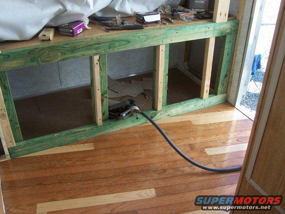 Interior camper construction with wooden framing and a power cord