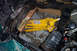 1995 Ford Taurus - A yellow jack is used to support wooden beams within the engine bay of a green vehicle.
