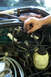 1995 Ford Taurus - Close-up of a hand working on the wiring harness in a vehicle's engine compartment.
