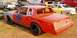 1966 Ford Fairlane - A modified race car with racing decals sits outdoors, with other vehicles in the background.