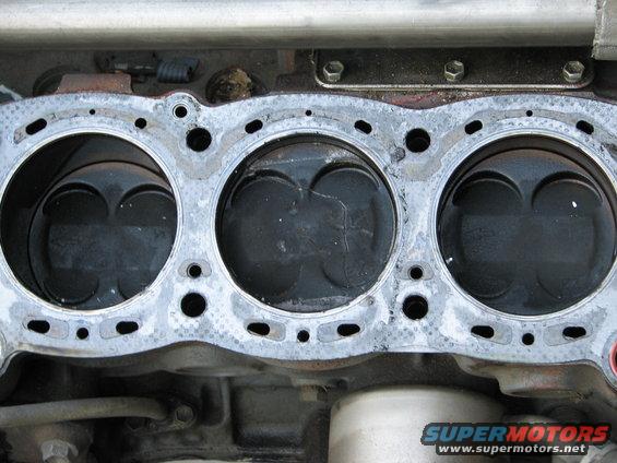 Engine block with pistons visible, showing wear
