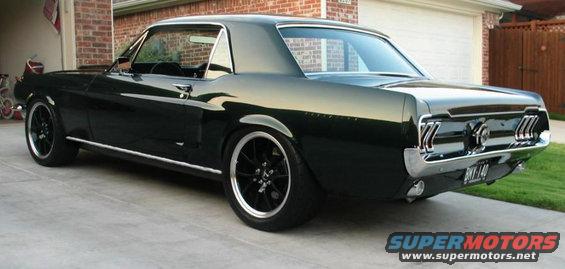 1966 Ford Mustang coupe, rear 3/4 view, dark green paint, aftermarket wheels