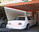 1999 Mercury Grand Marquis - Rear view of a white 1999 Mercury Grand Marquis parked under an awning.