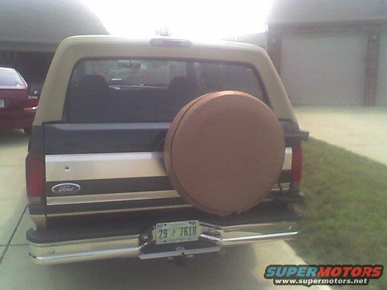 Rear view of a tan and brown Ford Bronco with a spare tire on the back. License plate reads 29 F 7618