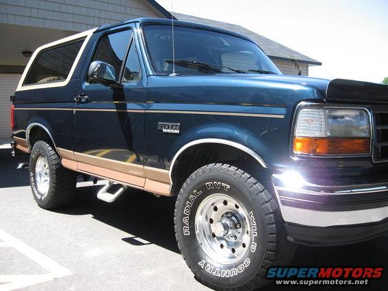 Dark blue 1994 Ford Bronco with tan lower trim and a white removable roof section