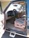 1994 Ford Bronco - The interior of a 1994 Ford Bronco features cloth seats and a tan dashboard.